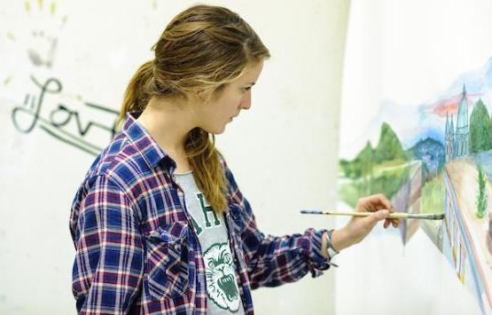 Ohio University student working on a painting in an art studio